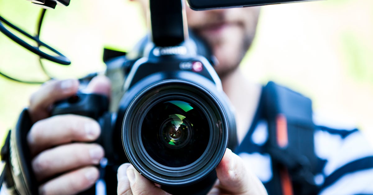 A close-up shot of a cameraman filming, focusing on the camera lens and equipment.